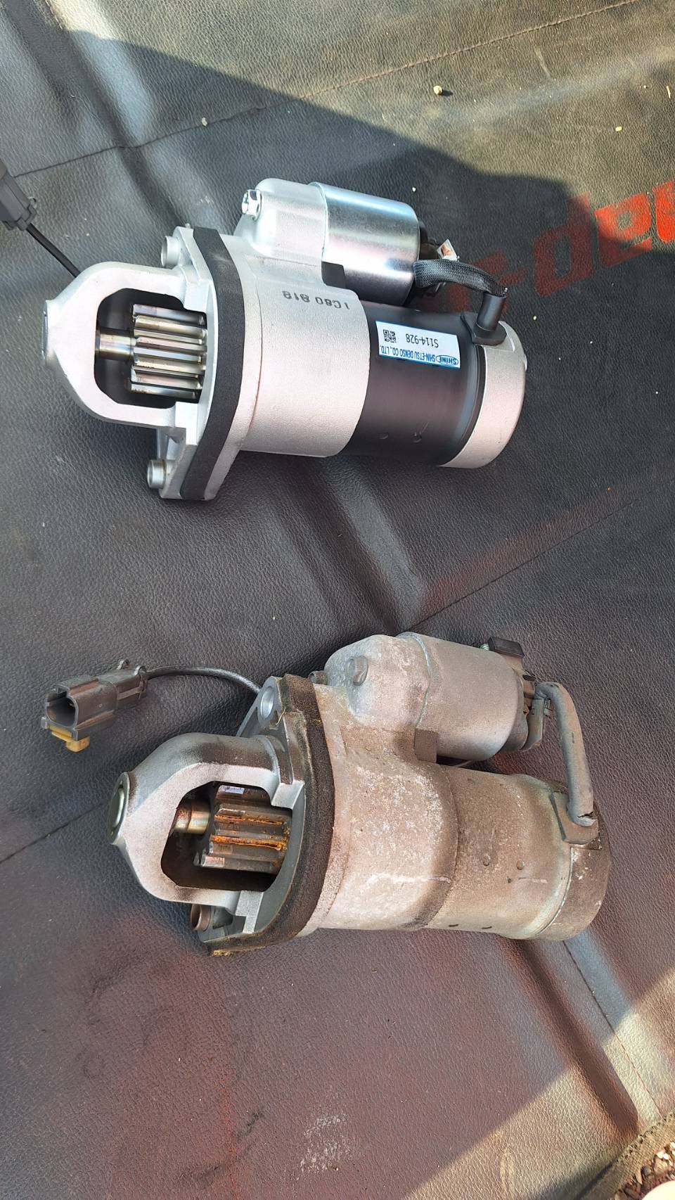 Z33のリビルトセルモーター（上）と取り外したセルモーター（下）の比較